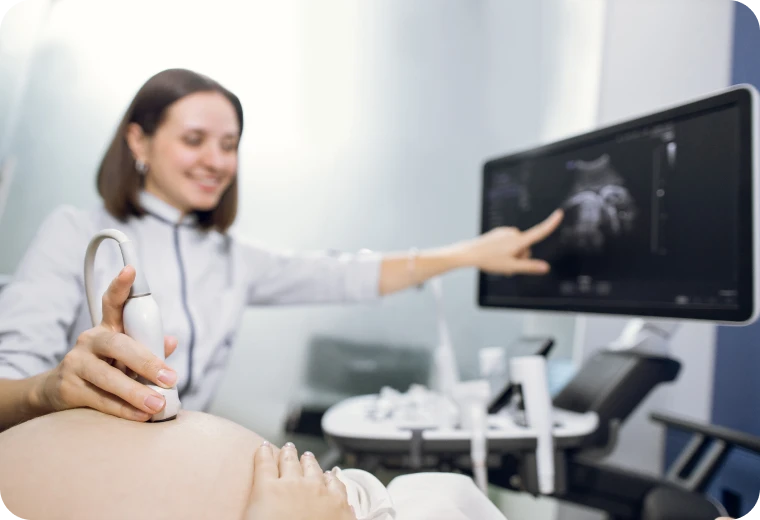 Médecin expliquant les résultats d'une échographie à sa patiente sur écran